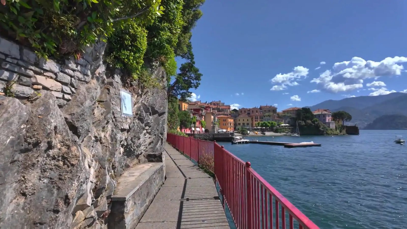 Idyllic Lakeside Walkway With A View Of Colorful Italian Village