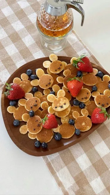 a plate topped with pancakes and fruit on top of a table