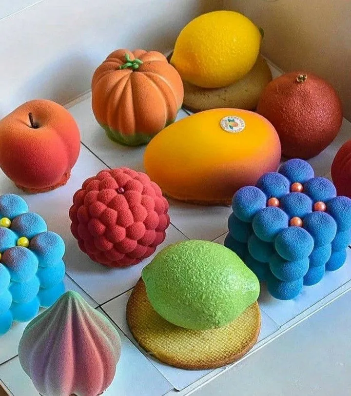 there are many different types of cakes in the box on the table, including oranges and lemons