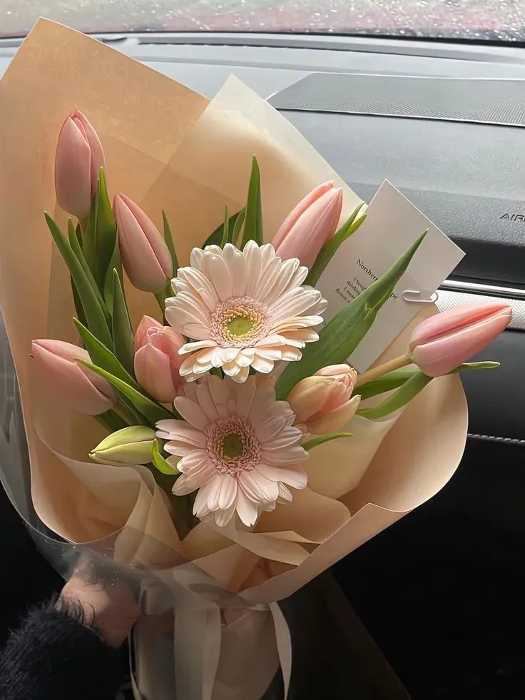 a bouquet of flowers sitting on top of a car dashboard