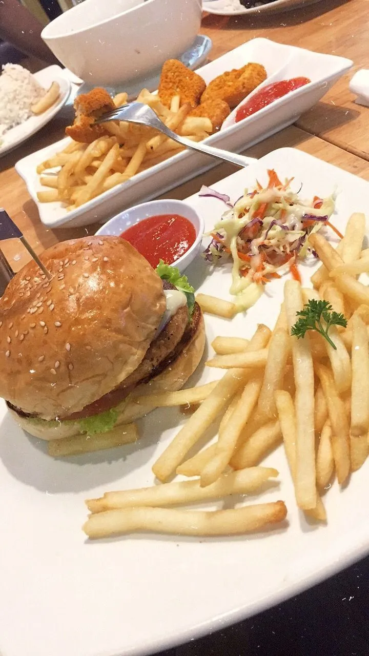a hamburger and french fries on a white plate