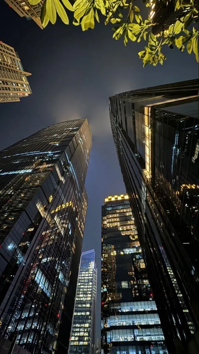 looking up at skyscrapers in the city at night