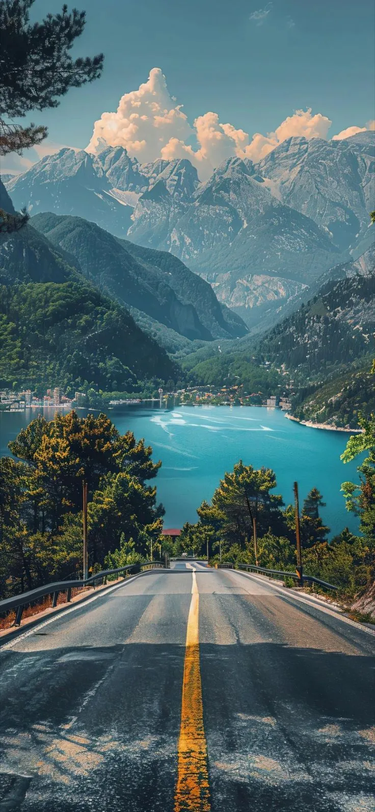 an empty road with mountains in the background and blue water on both sides, surrounded by pine trees