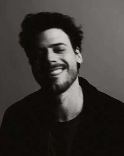 a black and white photo of a man smiling