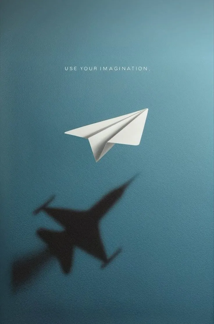 a paper airplane is flying in the sky next to a shadow of a fighter jet