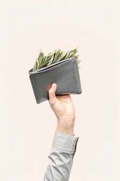A photo of a hand holding a small, dark-colored wallet...
