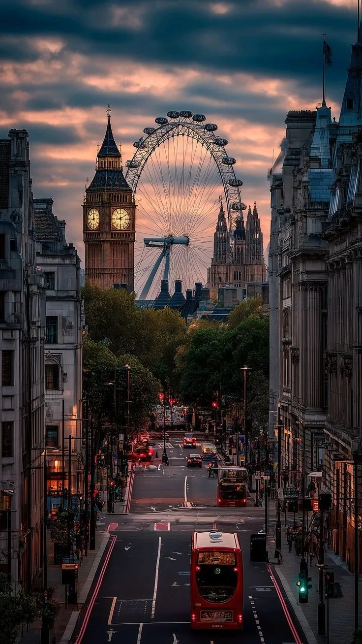 a red double decker bus driving down a street next to tall buildings with a ferris wheel in the background