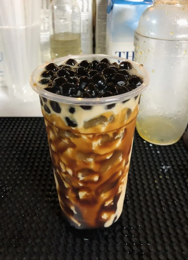 an iced drink with blackberries in it on a table
