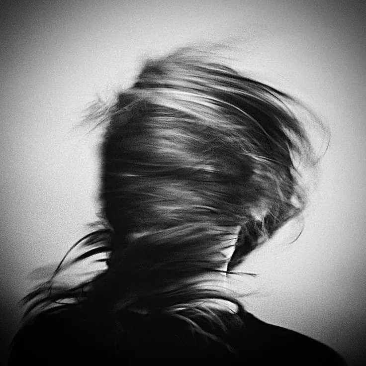 a woman with her hair blowing in the wind