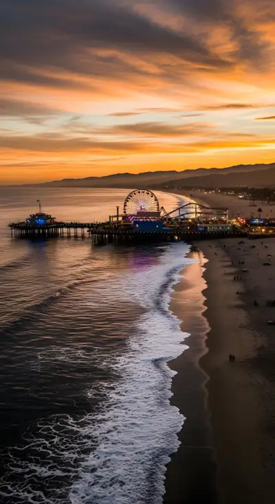 an ocean beach with a ferris wheel in the distance