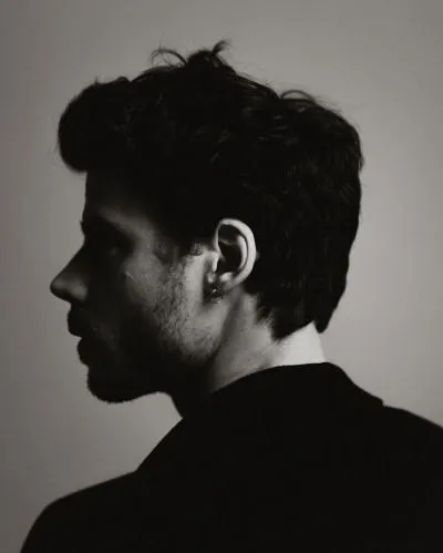 a black and white photo of a man with ear piercings