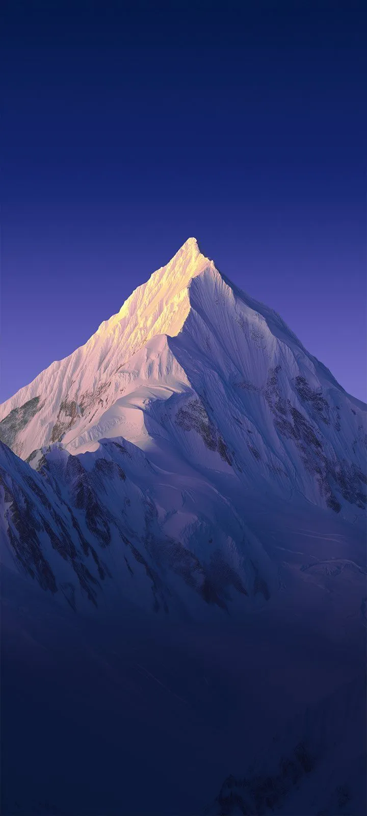 the top of a snow - capped mountain is lit up at night with blue skies