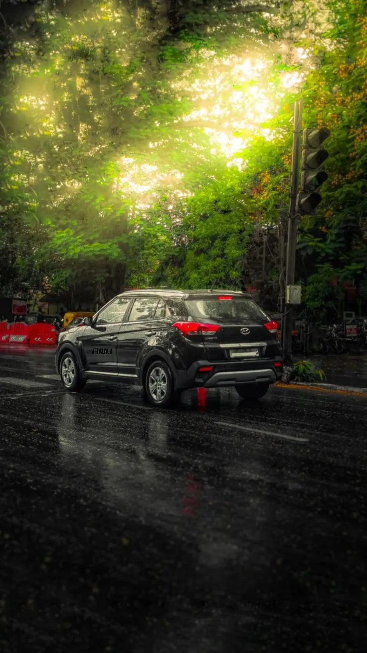 a car is driving down the road in the rain
