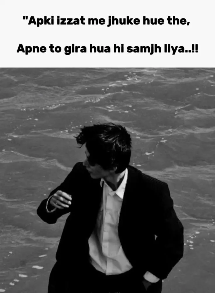 a man in a suit and tie standing next to the ocean with his hands on his hips