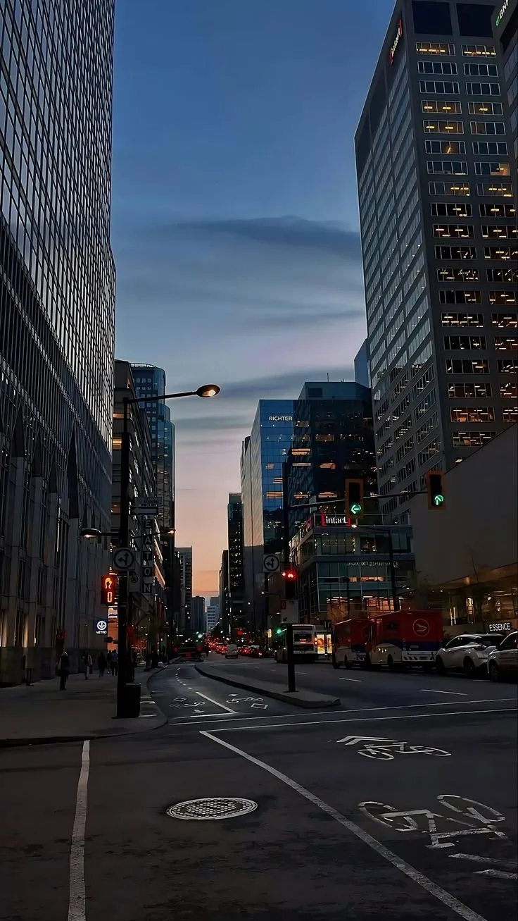 an empty city street at dusk with tall buildings