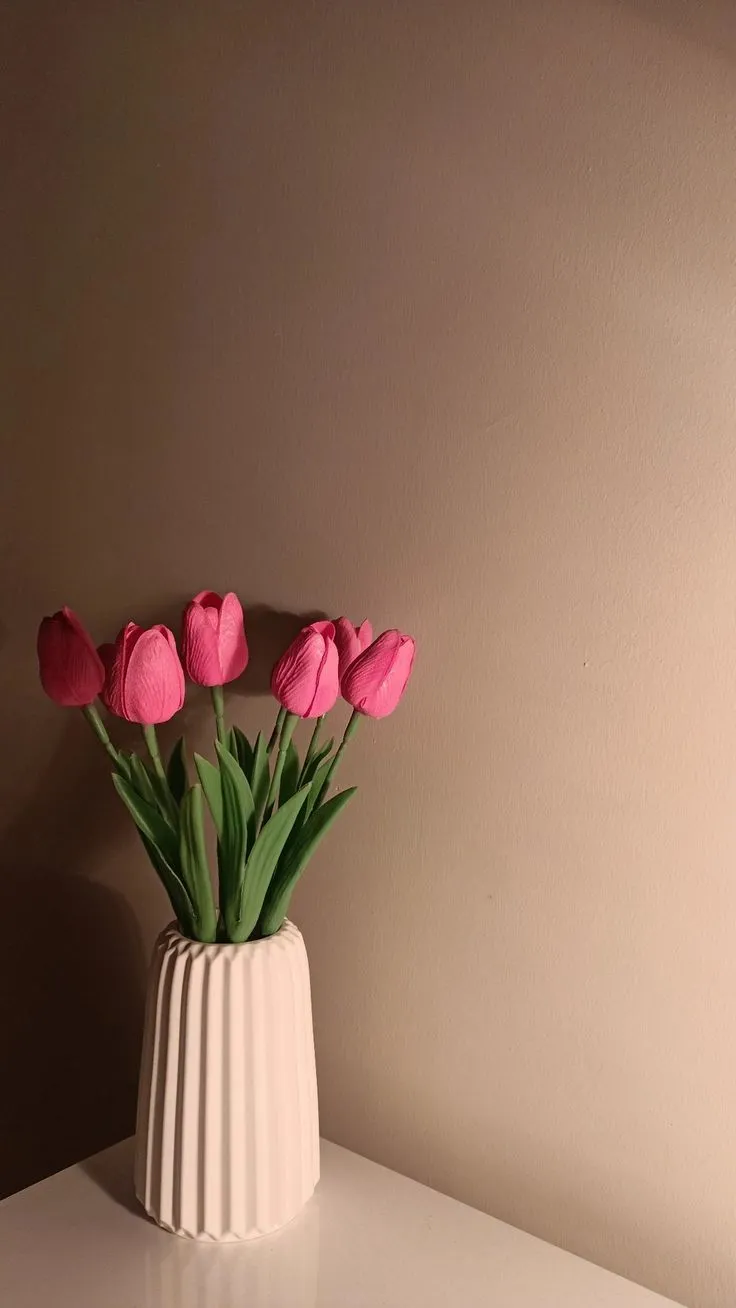 some pink flowers are in a white vase