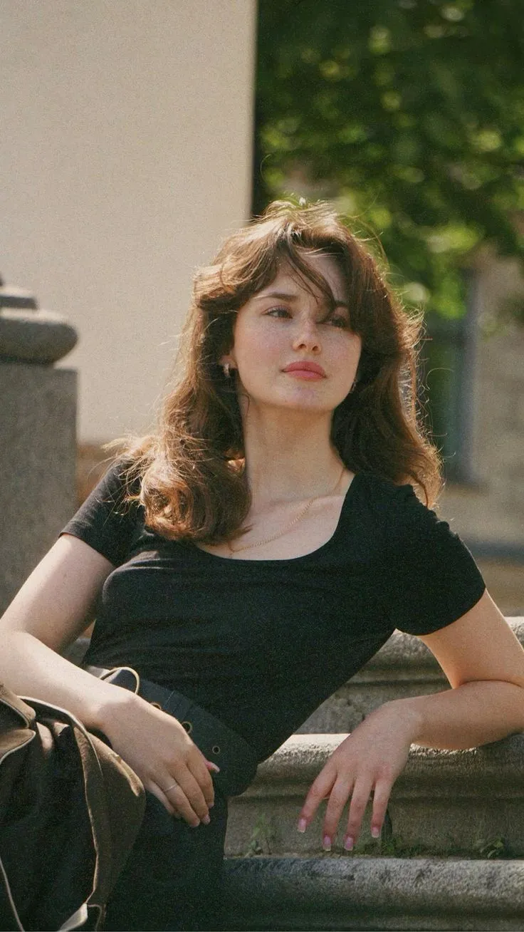 a woman sitting on top of a stone bench
