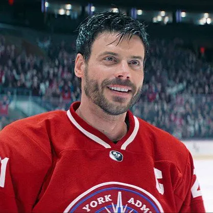 a hockey player is smiling for the camera