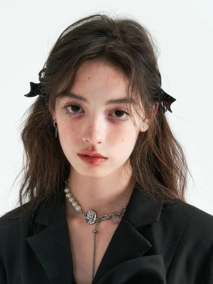 a young woman with long hair wearing a black jacket and pearl choker on her neck