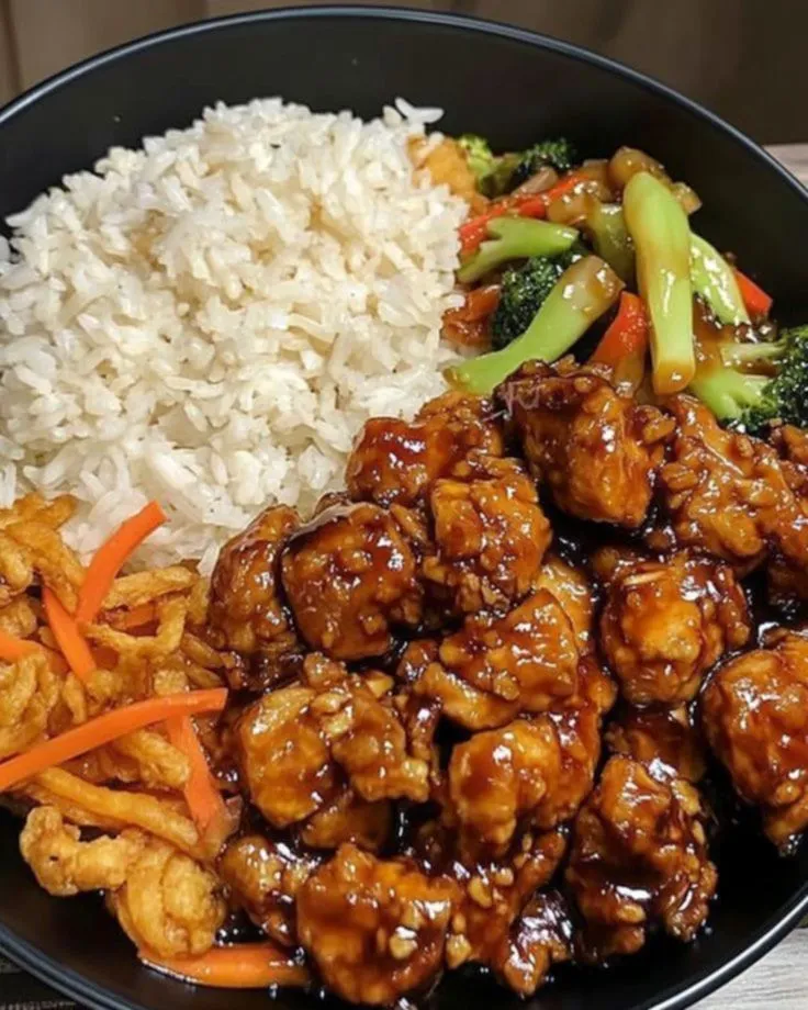 a black plate topped with rice and meat