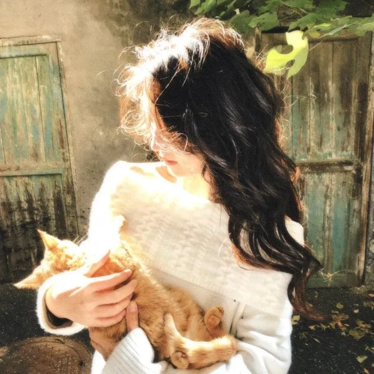 a woman holding a cat in her arms