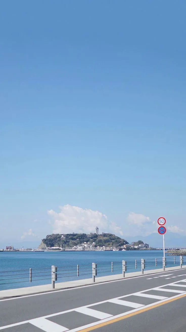 an empty street next to the ocean with no cars on it