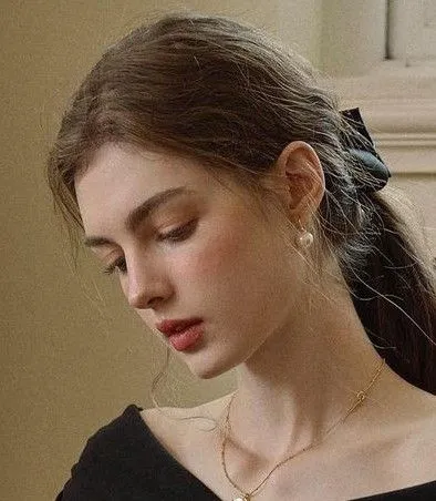 a woman wearing a black dress and holding a cell phone